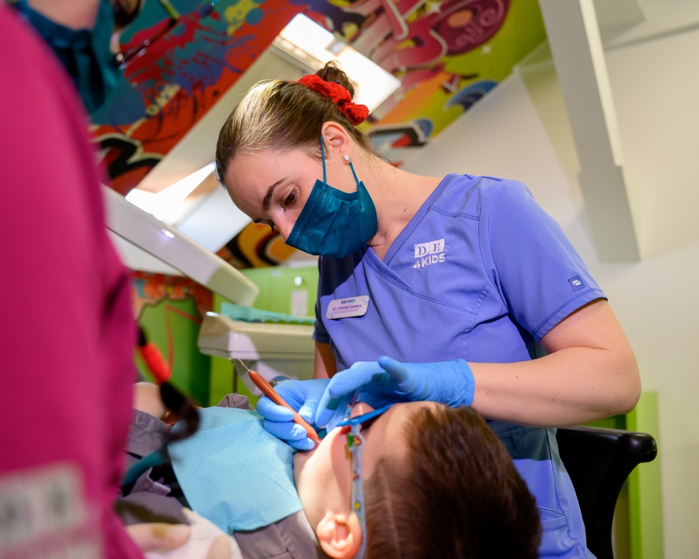 Medic dentist Timișoara - Dr. Cristina Curescu realizând tratamente dentare copii